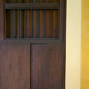 A typical hacienda door is quite tall, often nine feet high, made of hardwoods without nails and treated in linseed oil. The windows in the top half let the breezes in, while the bars keep the bats out. <a href=></a>
