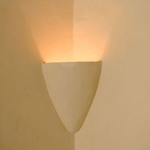 In early hacienda construction, plaster sconces were sculpted into the corners of walls, up high near the ceiling. They held torches, candles or oil lamps. This modern version uses electricity. <a href=></a>