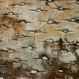 On many perimeter walls, a trowel is used to create a pattern that is filled with small stones, as on this aged chichum wall. <a href=></a>